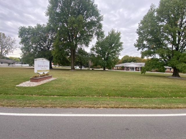 Front signage with grass and view of Bodine Chapel Day & Genda Funeral Home in IN.