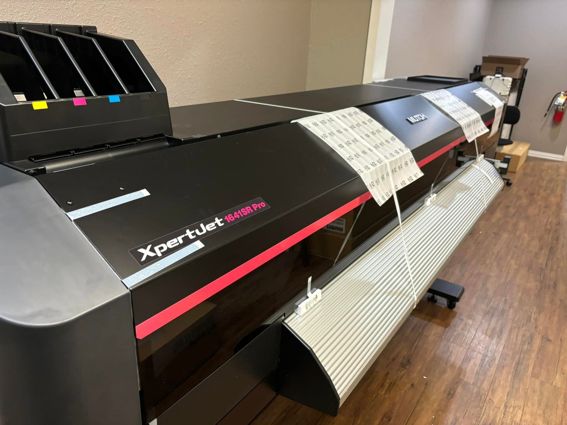 Large black Xpertjet 1641SR Pro printer with pink accents, paper guides, and ink cartridges.