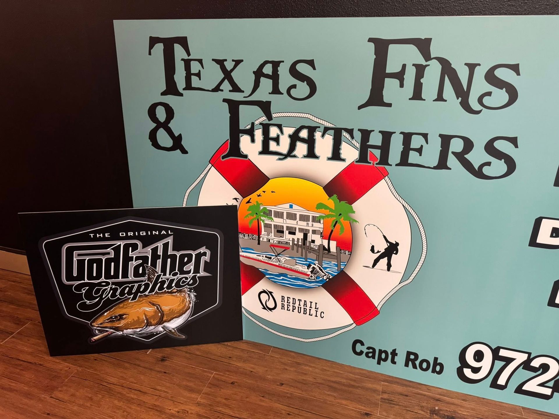 Texas Fins & Feathers sign with life preserver graphic and a Godfather Graphics sticker.