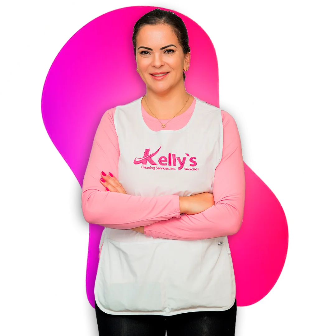 Woman in white apron with logo, arms crossed, in front of a pink blob.