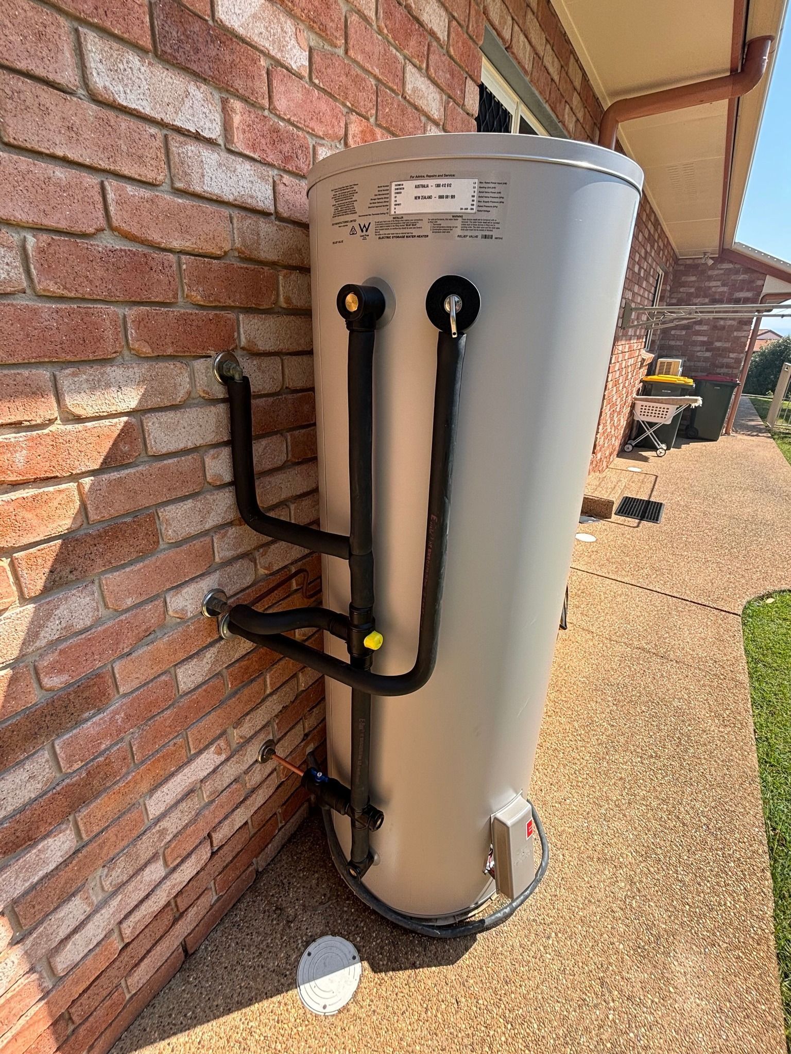 A Outdoor Hot Water Cylinder With Black Insulated Pipes — Truflow Plumbing & Gas Solutions in Rockhampton City, QLD