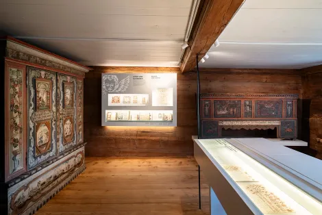 Historischer Ausstellungsraum im Ackerhus mit bemalten Bauernmöbeln und alten Schriftstücken