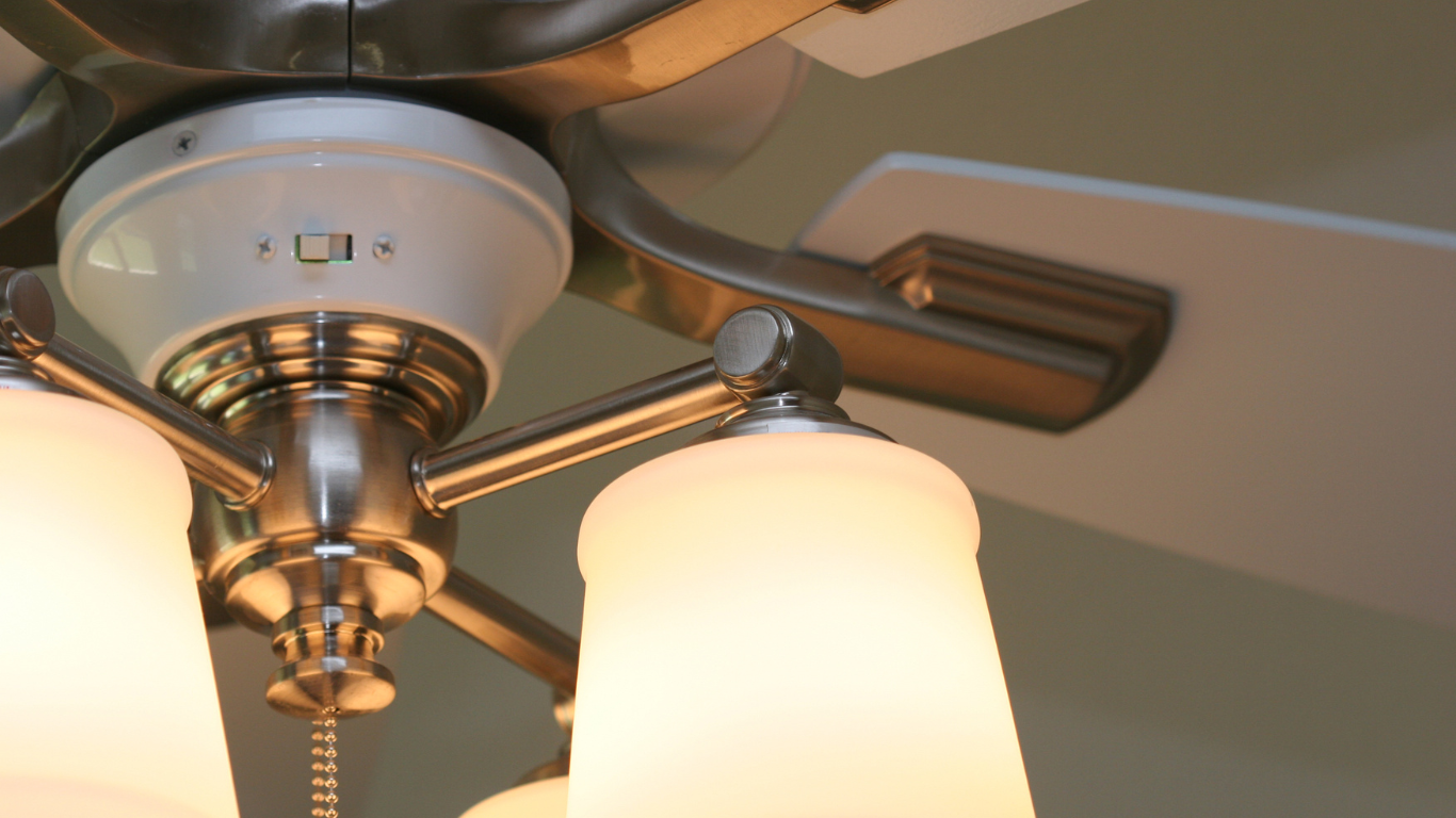 Ceiling fan with frosted glass lights, brushed metal accents, and a white blade.