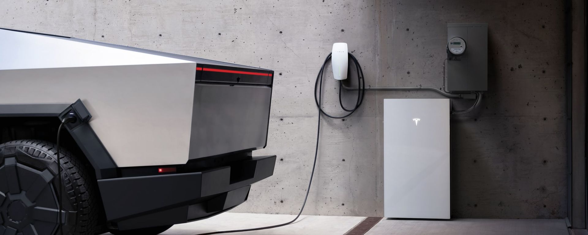 Tesla Cybertruck charging next to a wall-mounted charging station and a Tesla Powerwall.