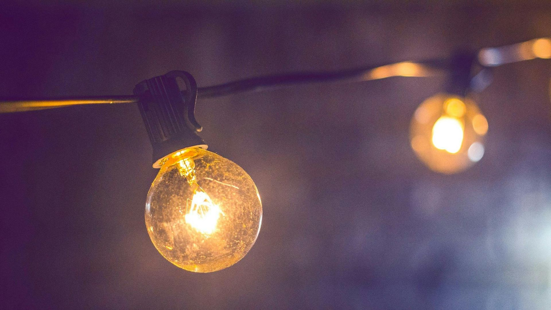 String lights with glowing, round bulbs against a dark background.