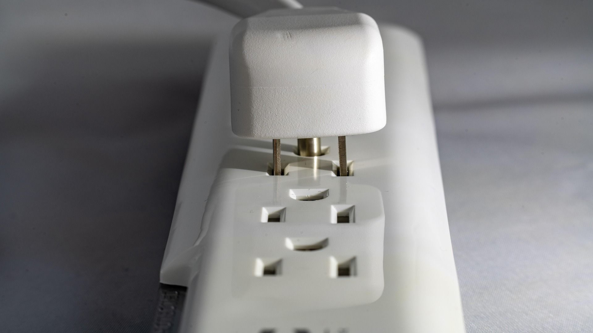 White power strip with a plug inserted.