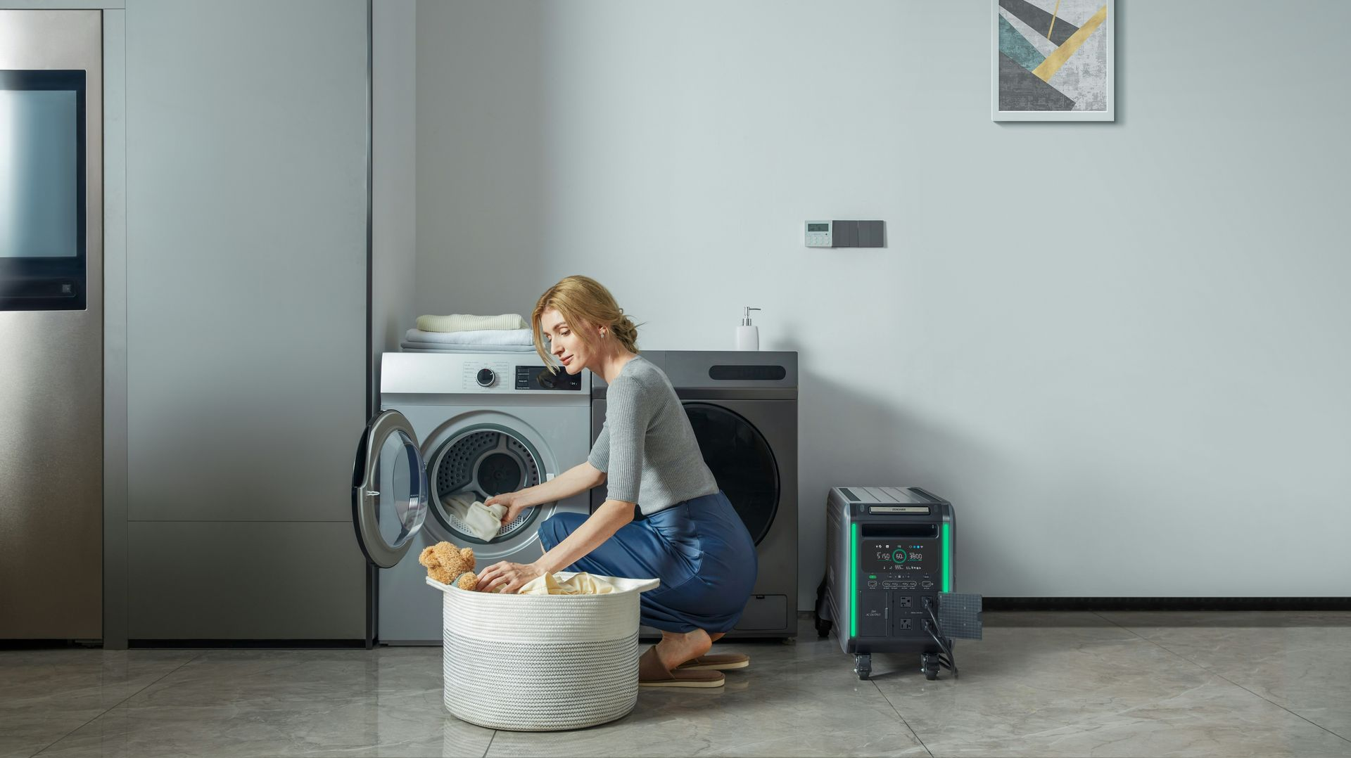 Woman loading clothes into a washing machine next to a portable dryer in a modern laundry room.
