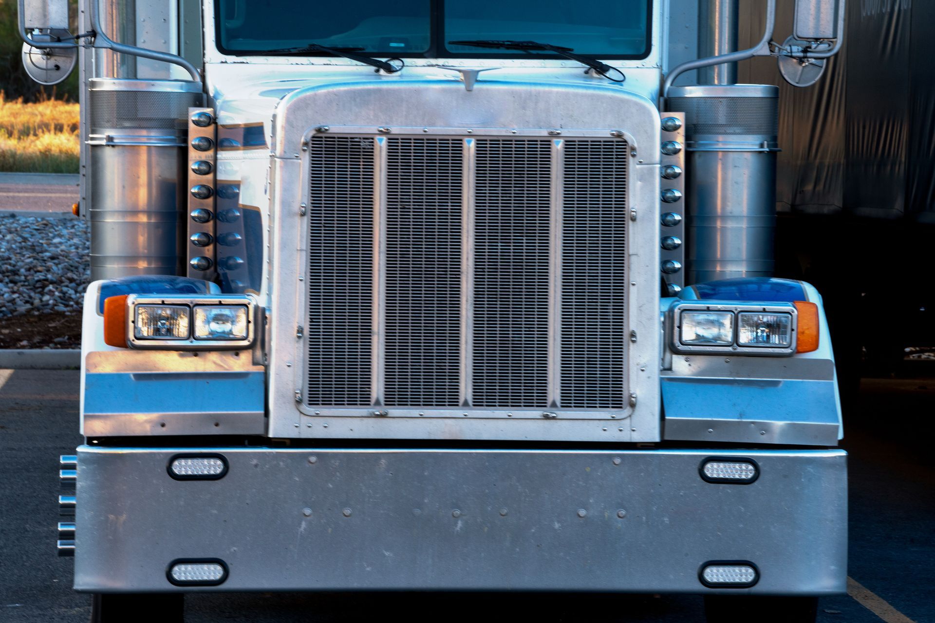 A front view wide-angle shot of a semi-truck in a parking lot.
