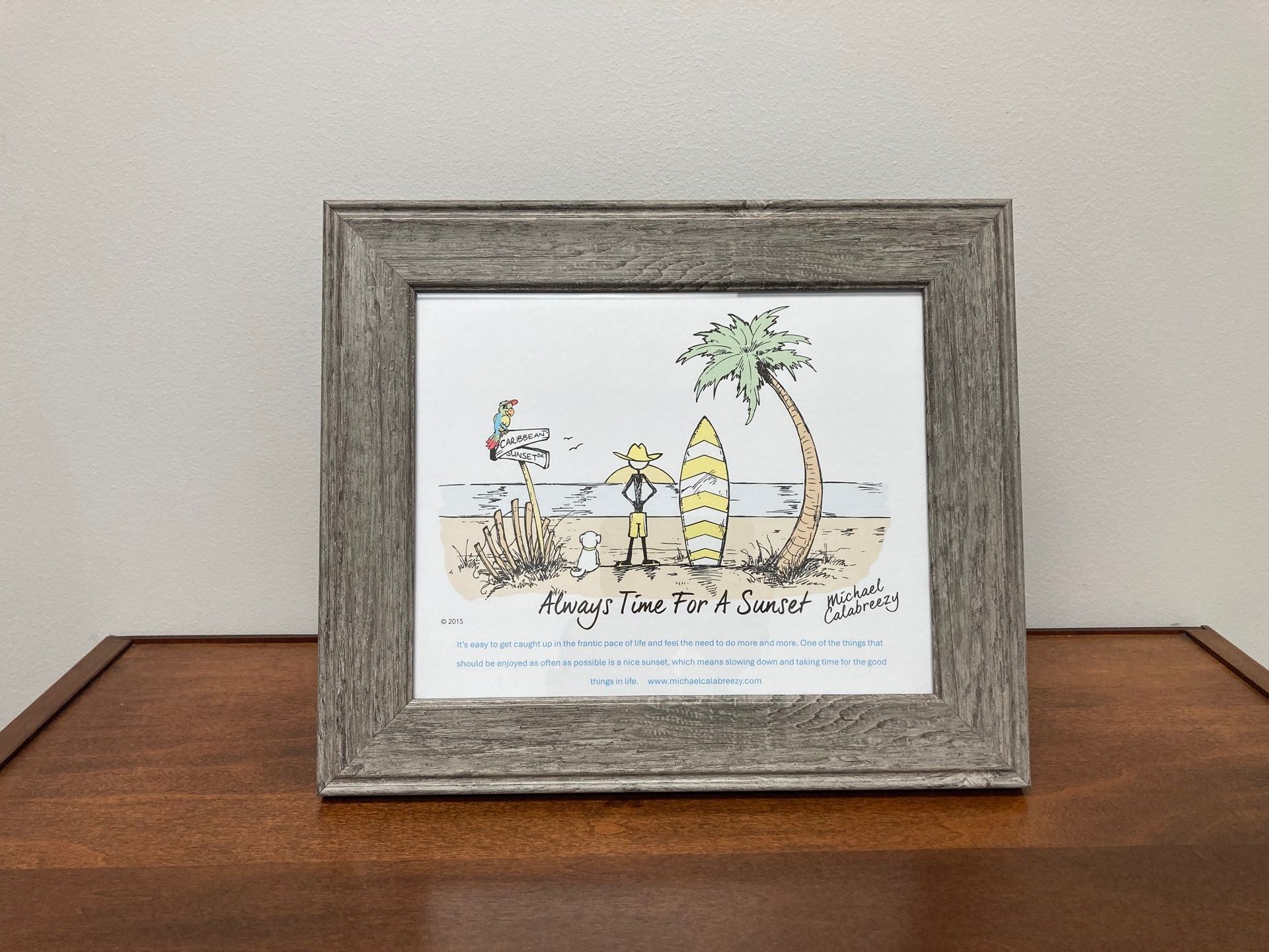 Framed cartoon of a beach scene: palm tree, surfer, seagull, sand, and