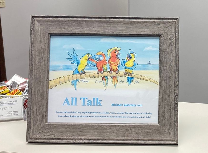 Reception desk with framed art, a floral arrangement, and a wall picture.