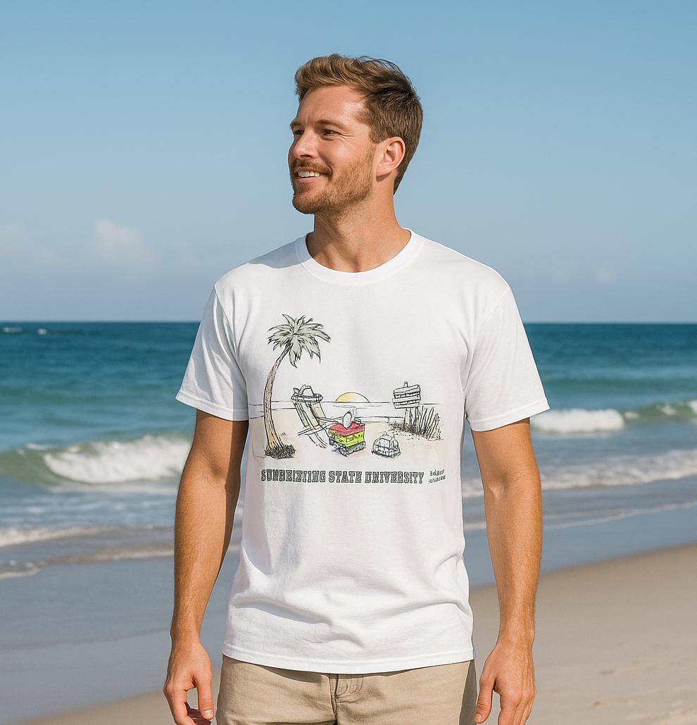 Man on beach wearing white t-shirt with cartoon scene.