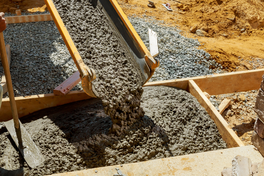 Concrete is being poured into a concrete foundation at a construction site.