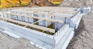 A concrete foundation for a house under construction with wooden beams.