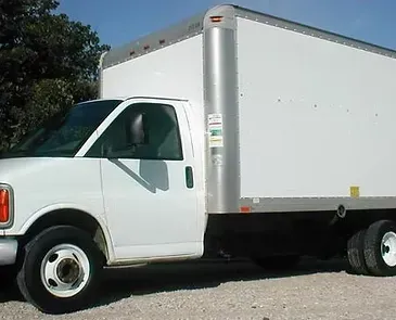 White box truck on a gravel lot.