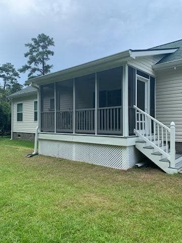A white house with a porch and a sliding glass door.
