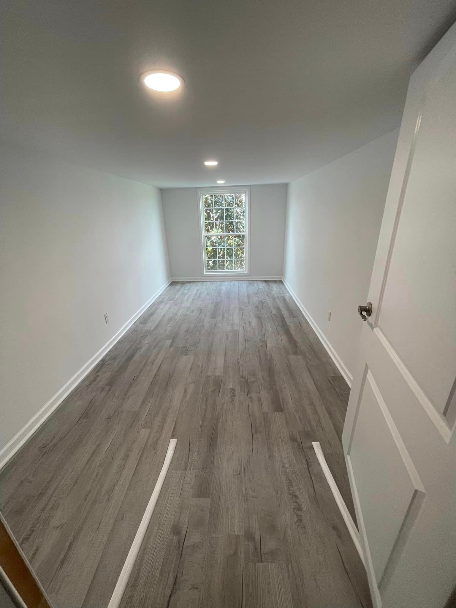 A room with a lot of drywall on the walls is being painted.