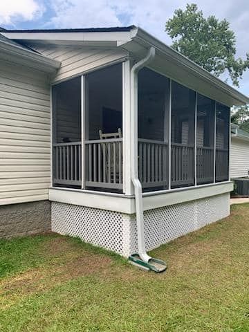 A screened in porch on the side of a mobile home.