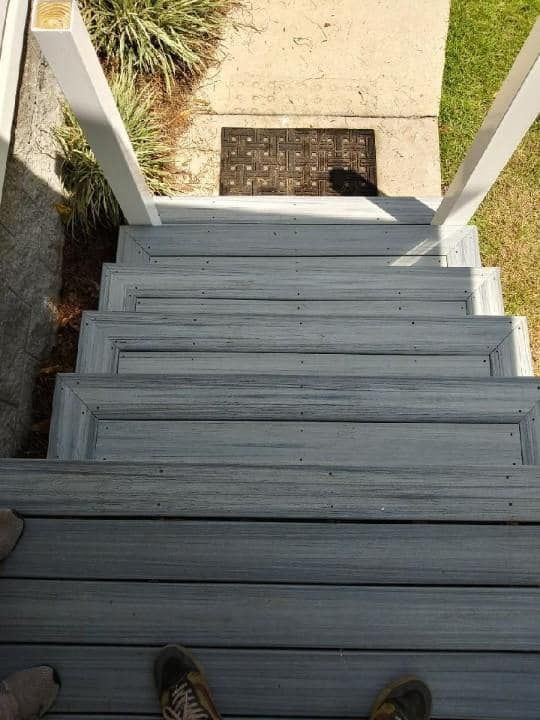 A person is standing on the bottom of a set of stairs.