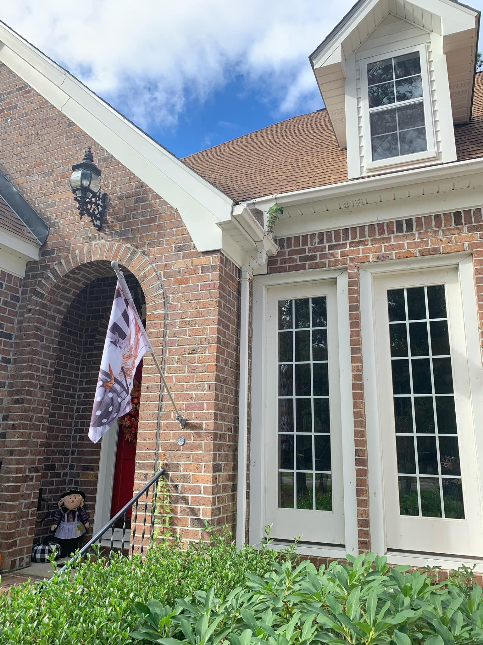 A brick house with a flag in front of it.