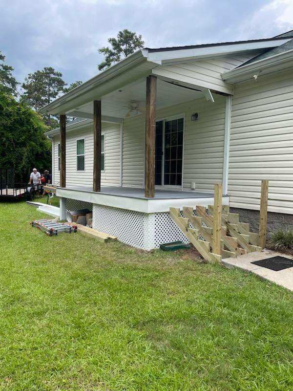 A house with a porch and stairs in the backyard.