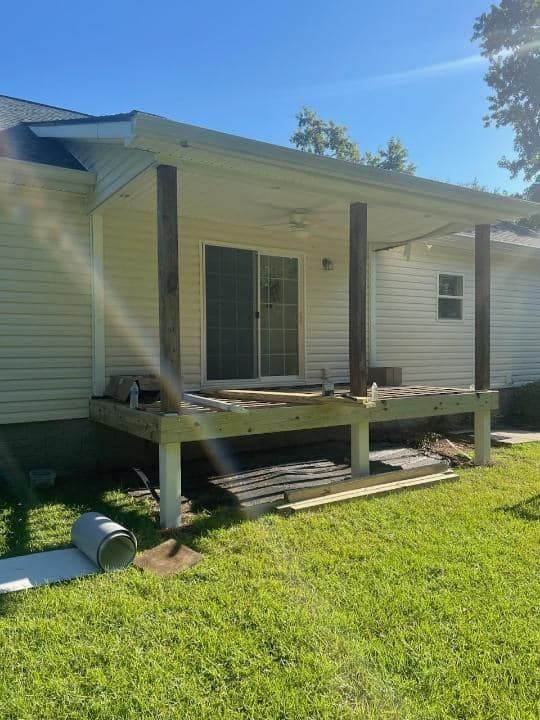 A white house with a porch and a sliding glass door.