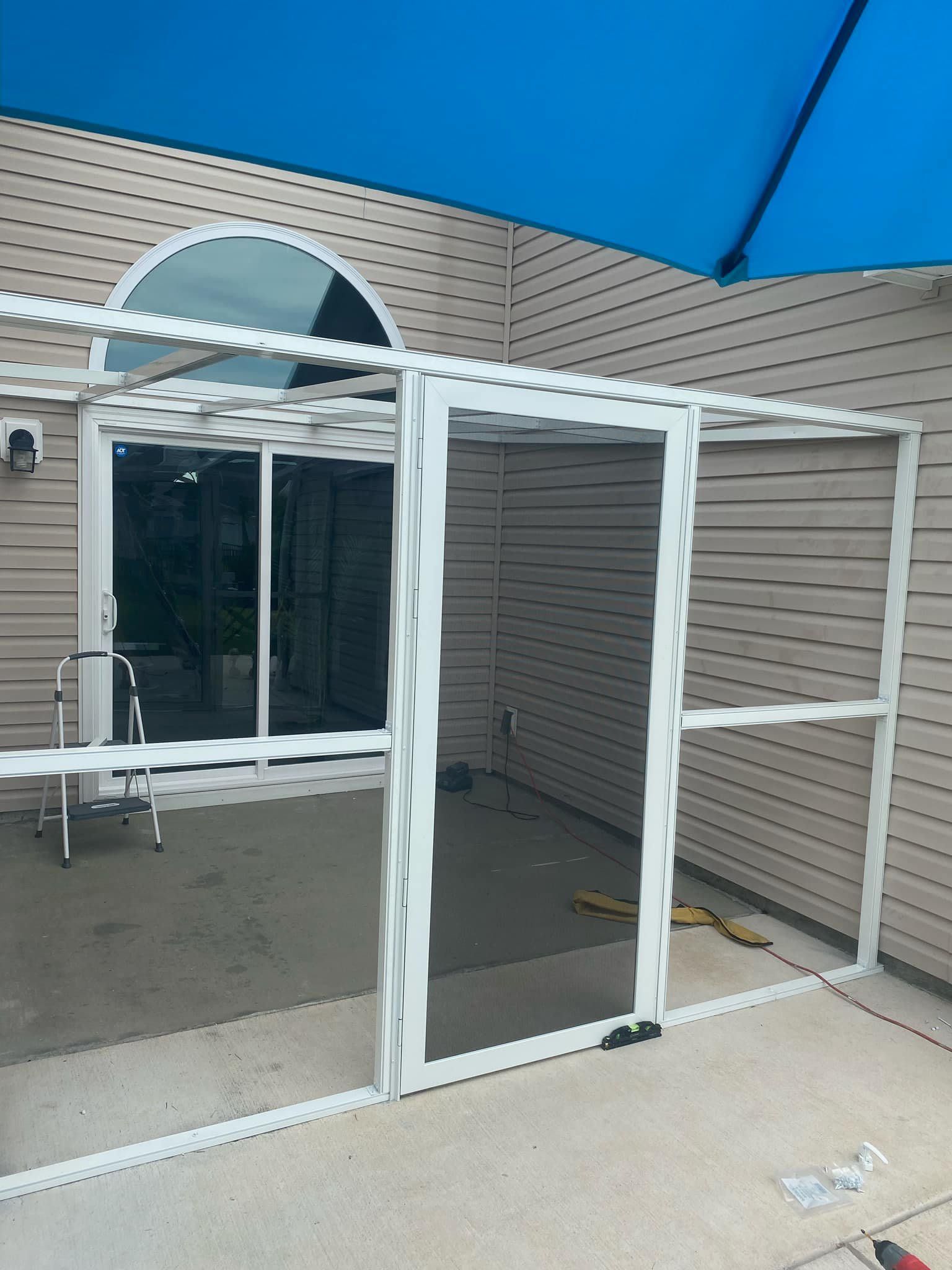 A screened in porch is being built on the side of a house.