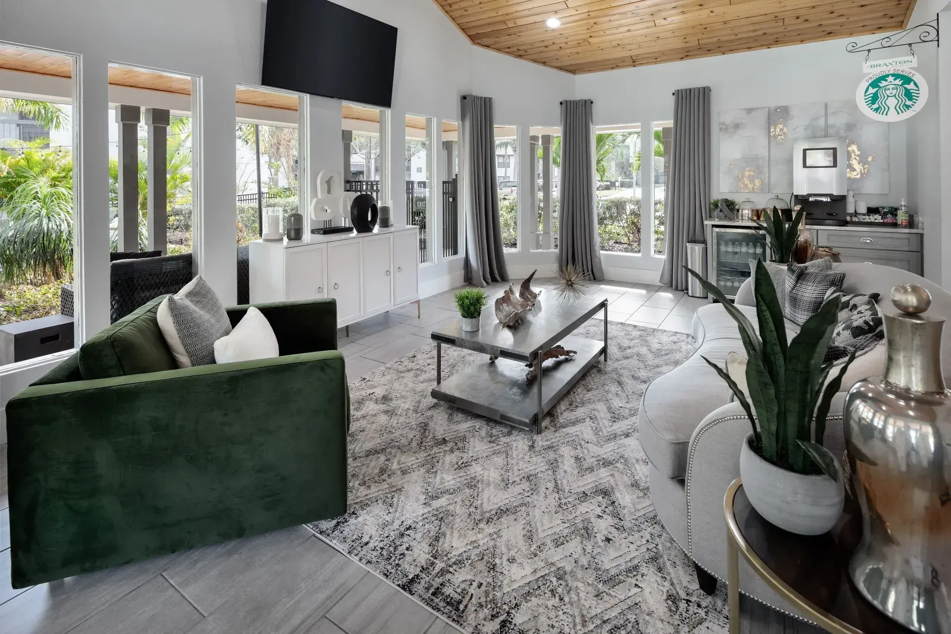 Luxurious living room with green sofa, marble coffee table, and Starbucks coffee station.