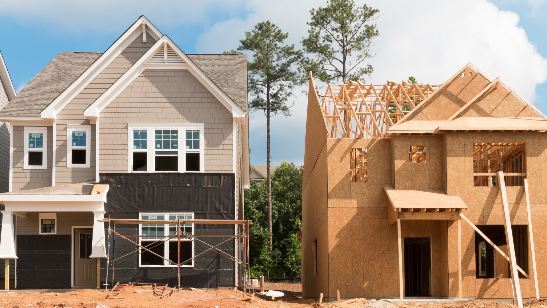 Houses under construction, one finished with siding, one with exposed wood framing.