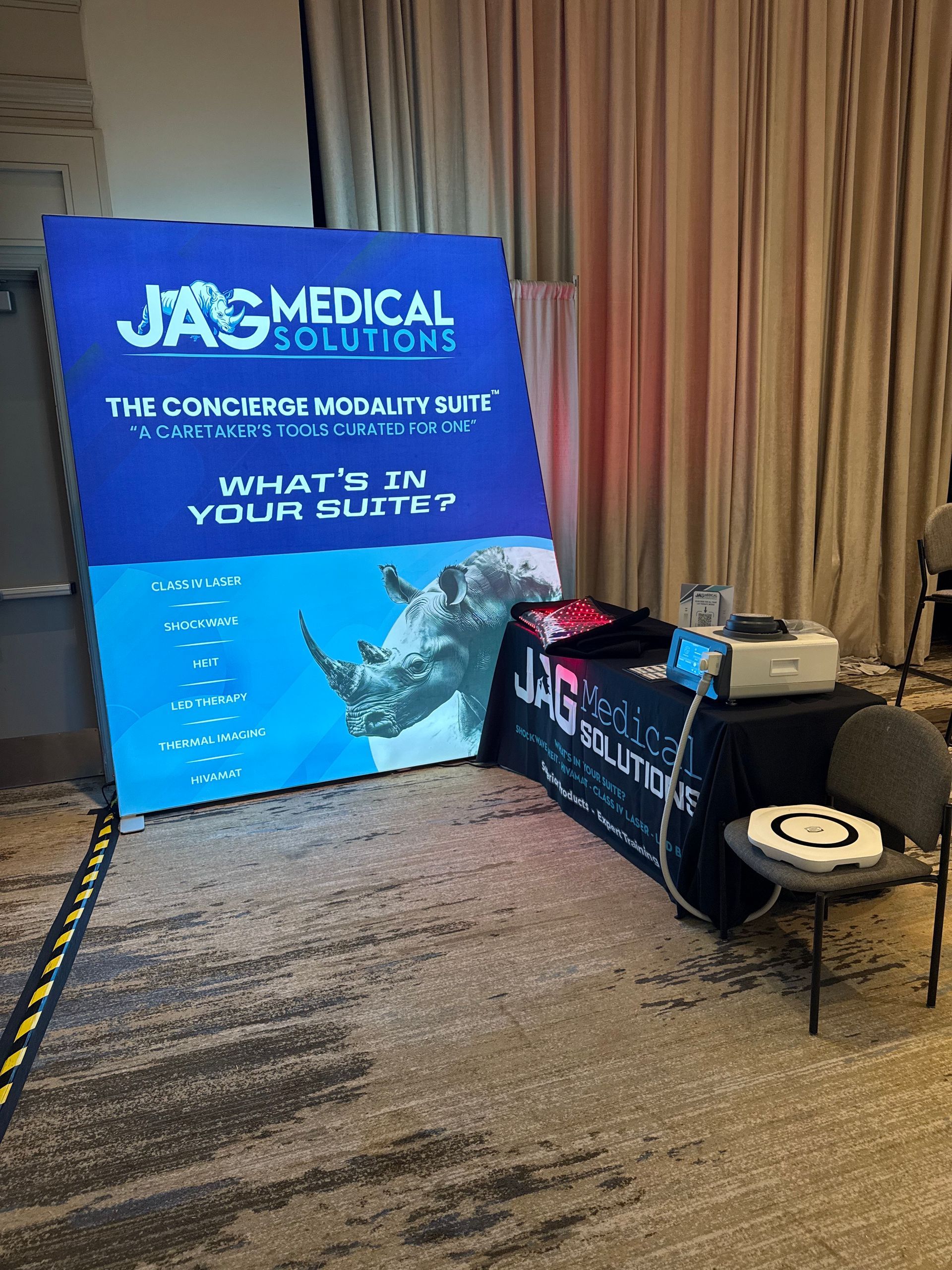 Jag Medical Solutions booth at an event. A large sign with rhino graphic and table with materials.