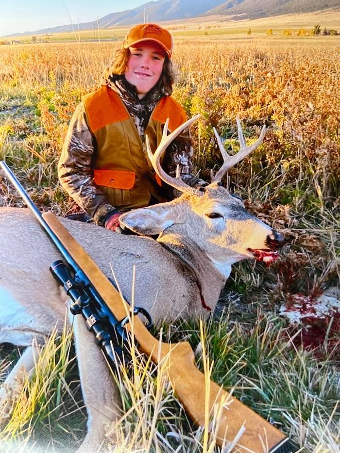 young boy holding a deer