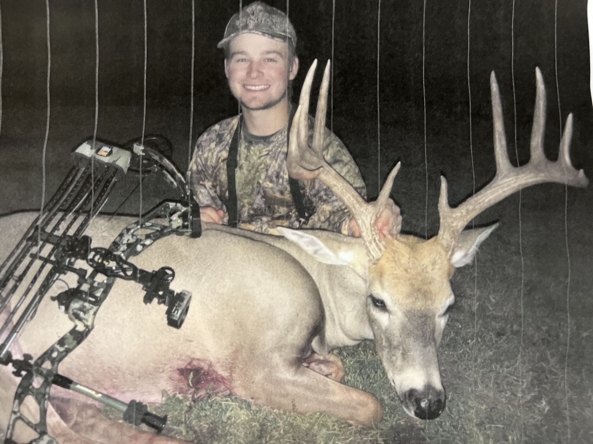 bow hunter holding a deer