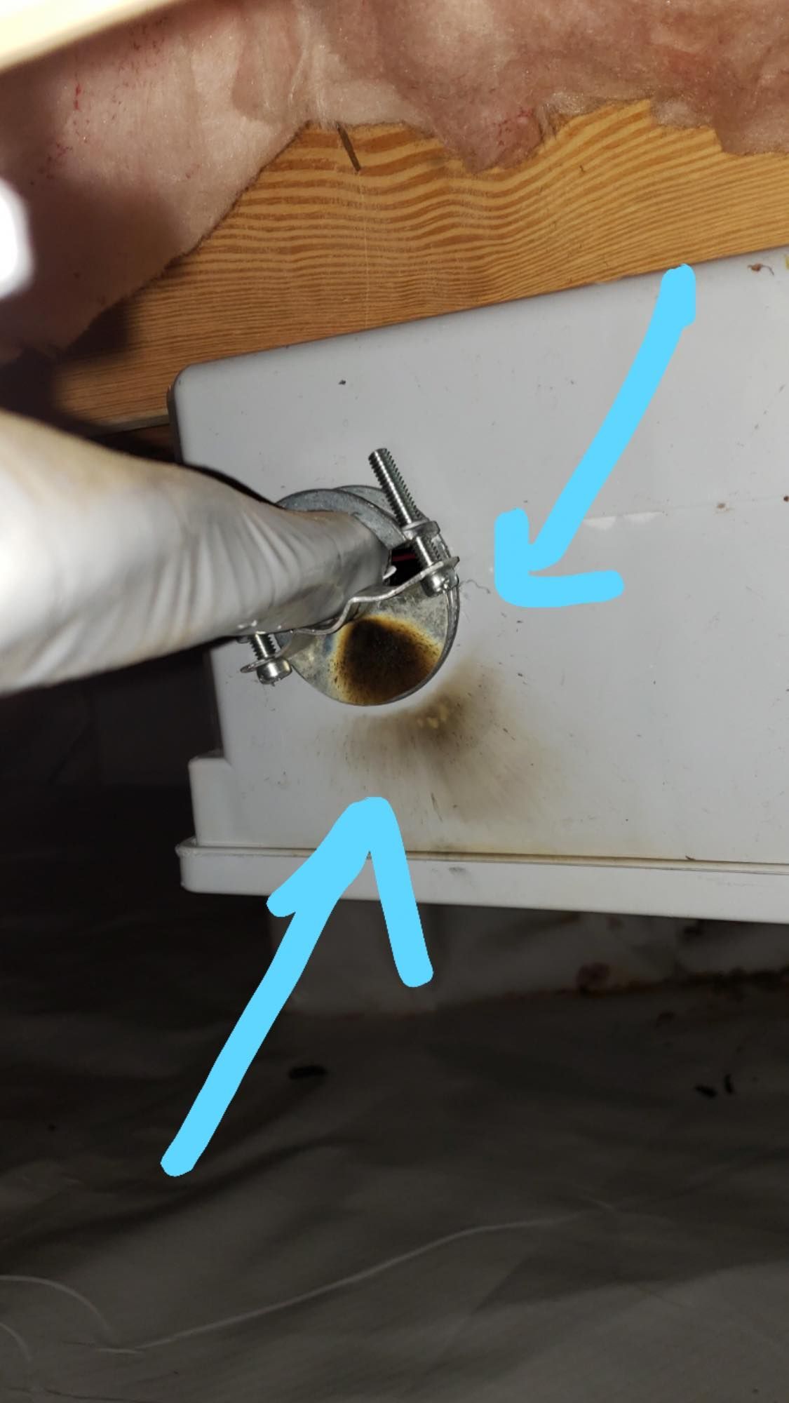 Plumber inspecting sink pipes, holding a clipboard and wrench. He wears a cap and jeans.