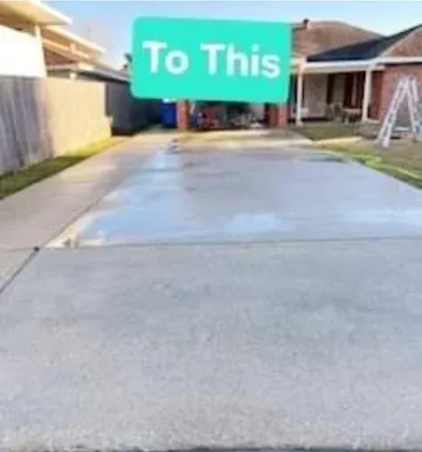 Clean, wet concrete driveway in front of a house, with the words 