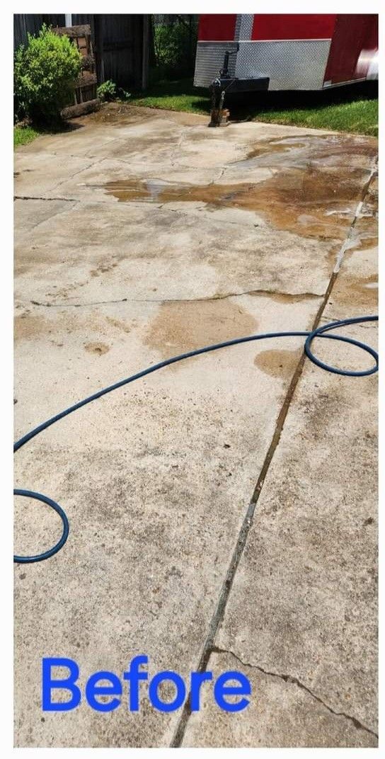 A concrete driveway with stains and cracks, a blue hose lies on the surface. The word 