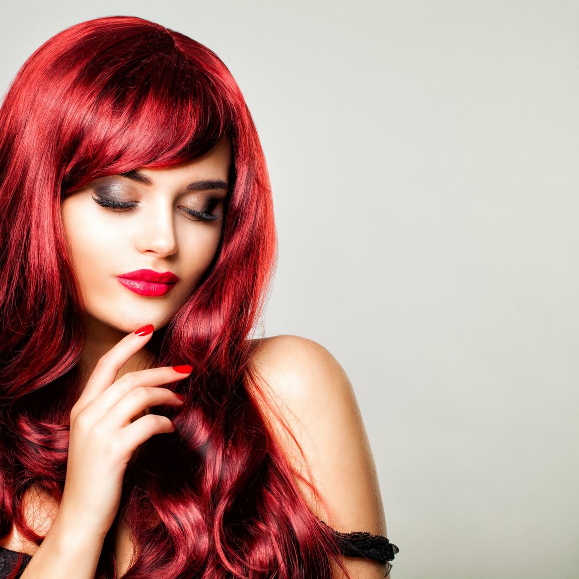 Glamorous Redhead Woman with Perfect Hairstyle and Makeup. Beautiful Model with Long Red Healthy Hair