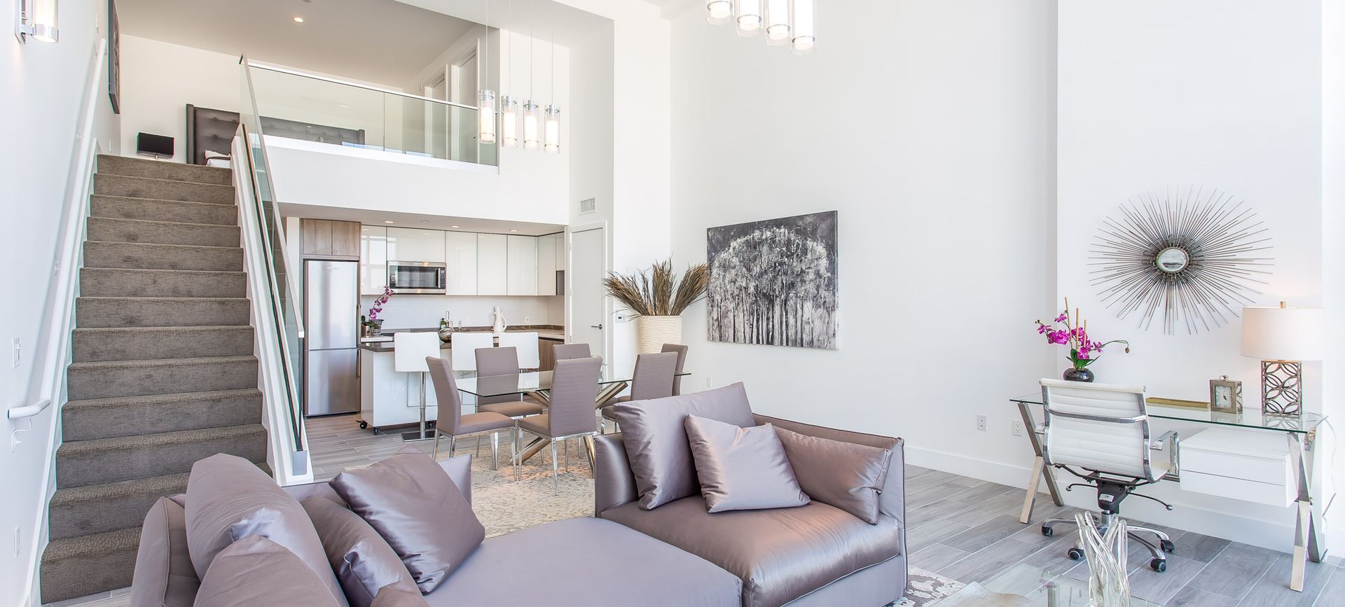 Spacious modern living area with staircase, open kitchen, and seating area.