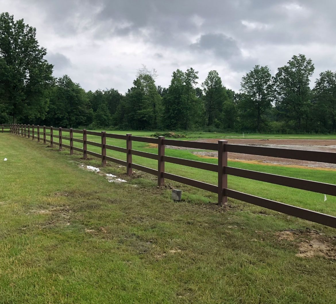 Lush cornfield with white fence and blue sky
