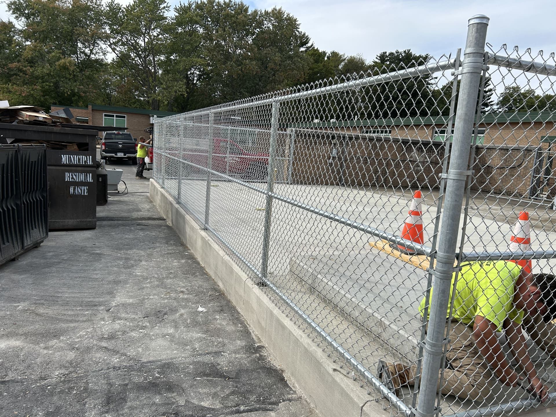 chain link fencing with soccer players in the field behind