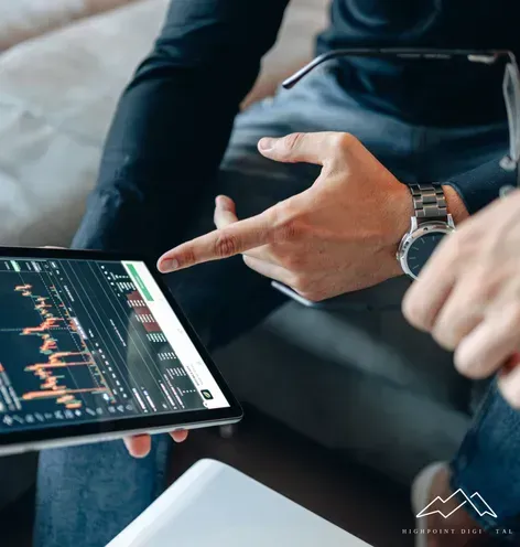 A man is pointing at a tablet with a graph on it.