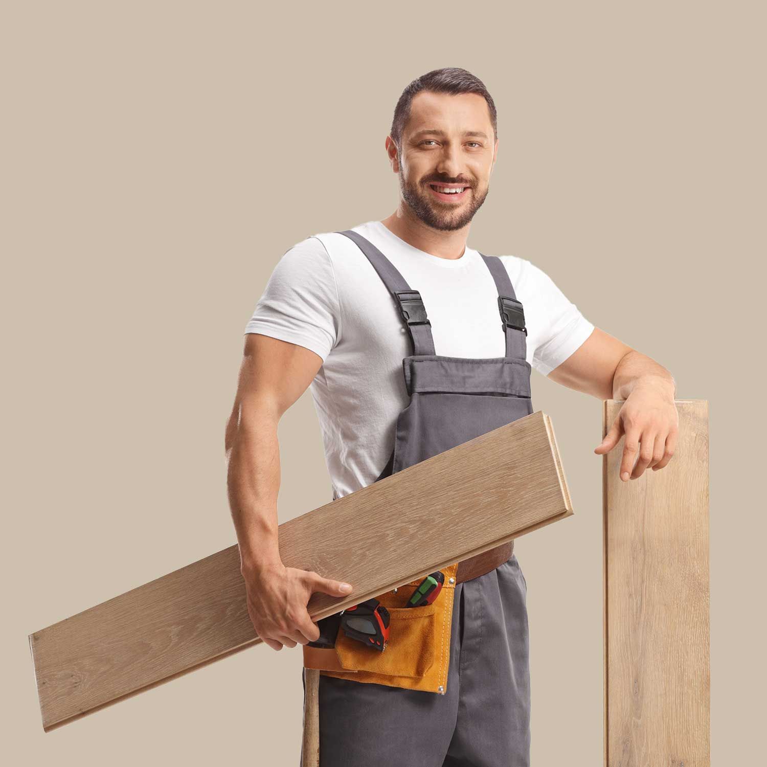 En mand i overalls holder et stykke træ.