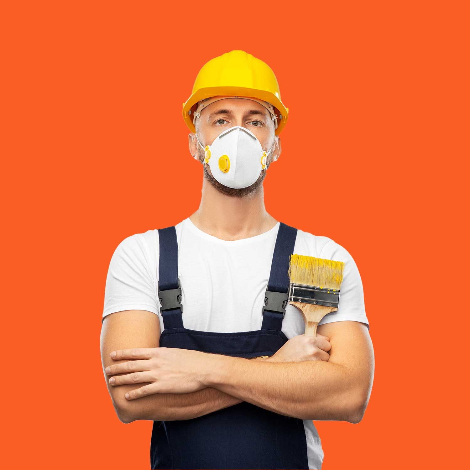 En mand iført en hård hat og en maske holder en malerpensel.