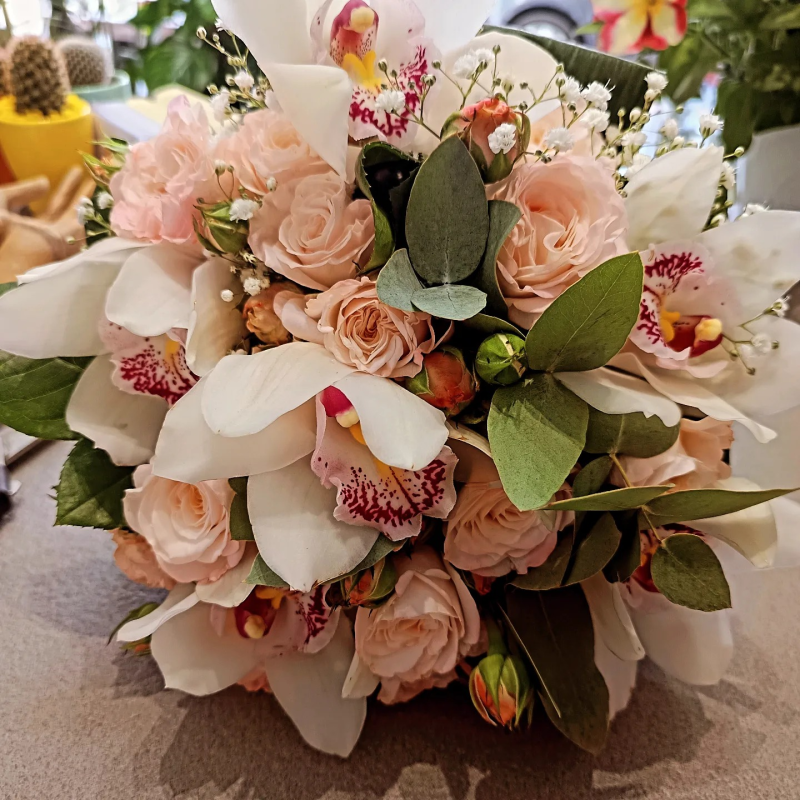 Un mazzo di rose rosa e orchidee bianche su un tavolo