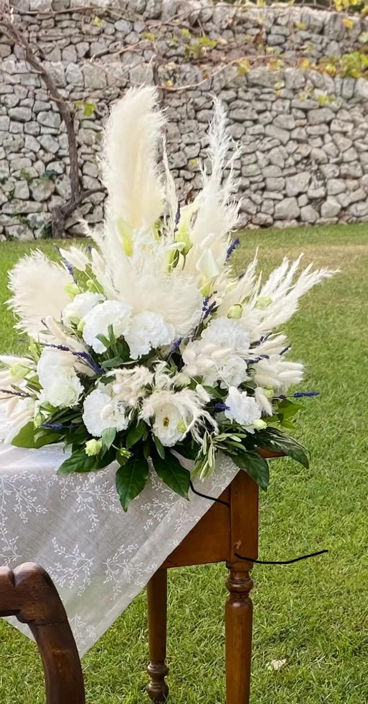 Un tavolo con sopra un mazzo di fiori bianchi.