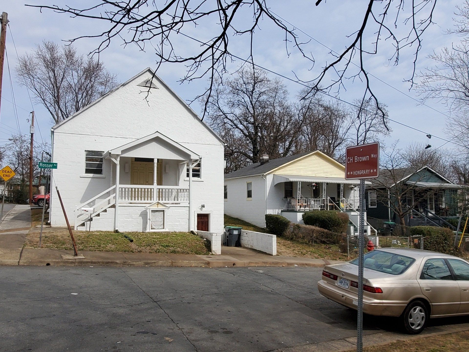 A car is parked in front of a white house