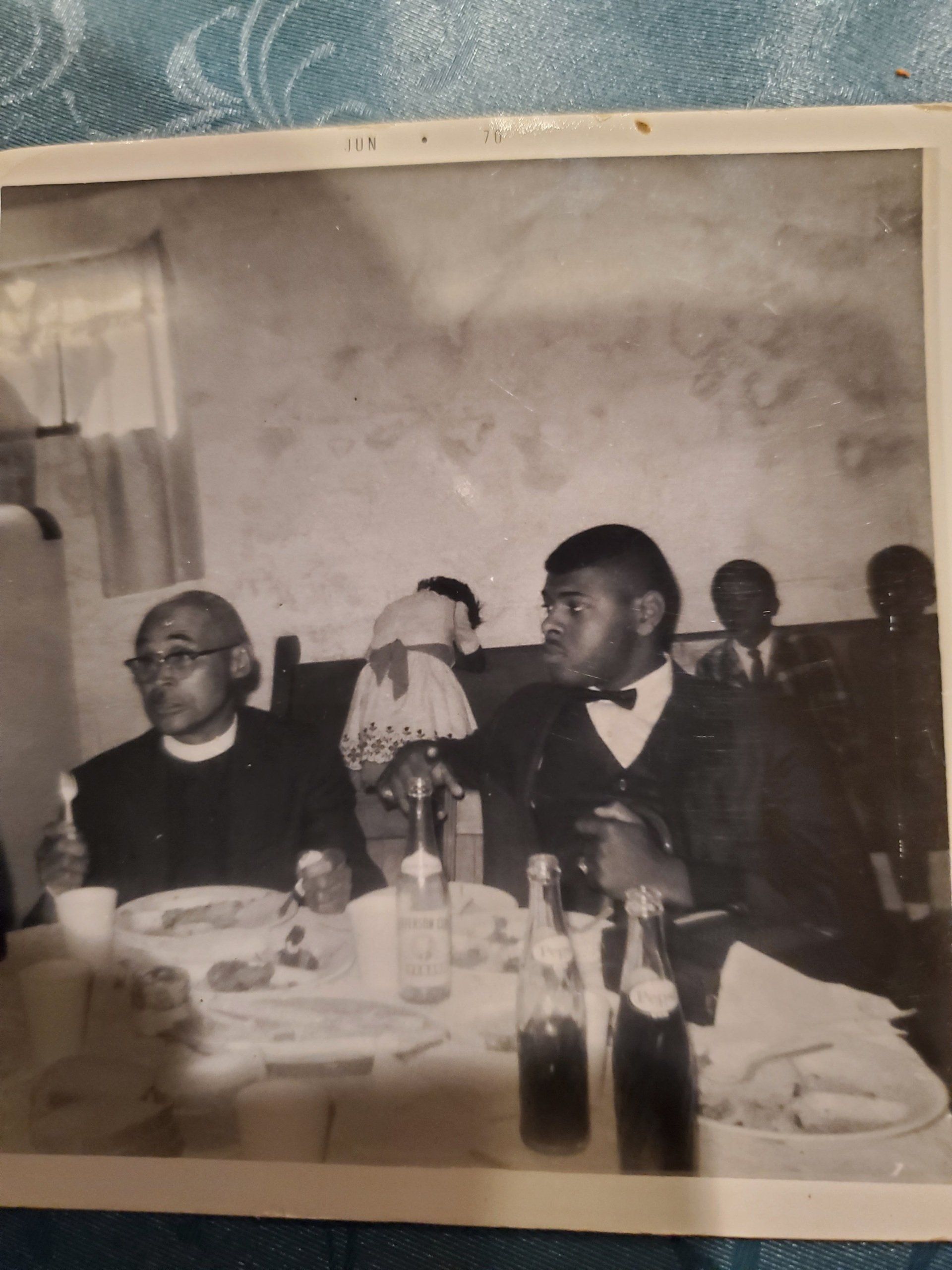 A black and white photo of people sitting at a table