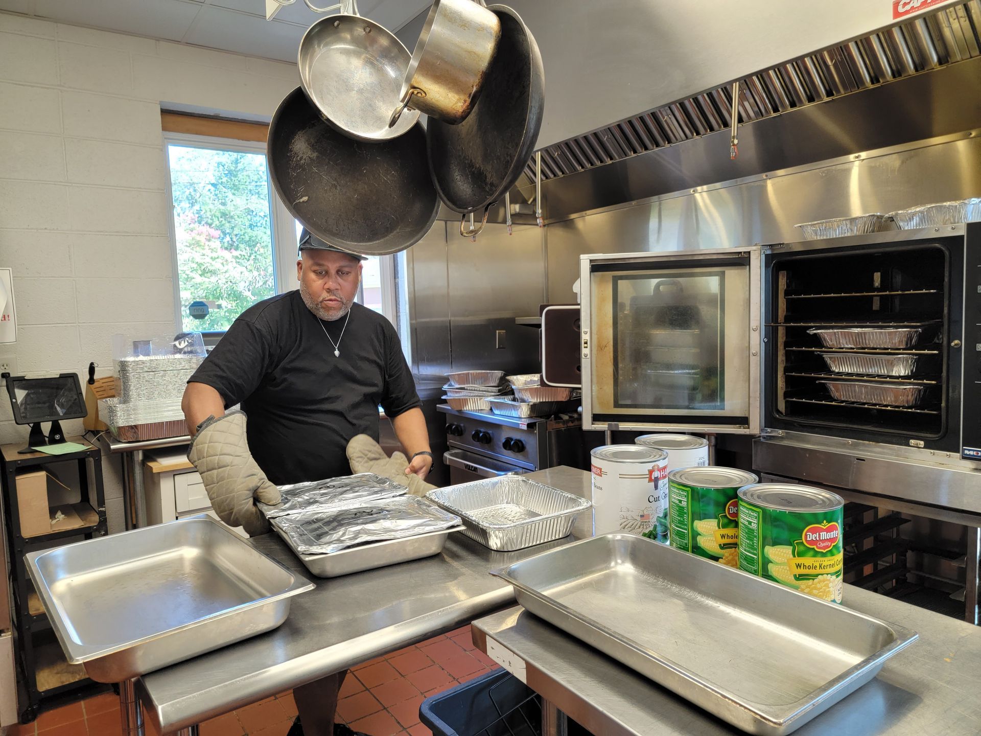 A man is standing in a kitchen preparing food.