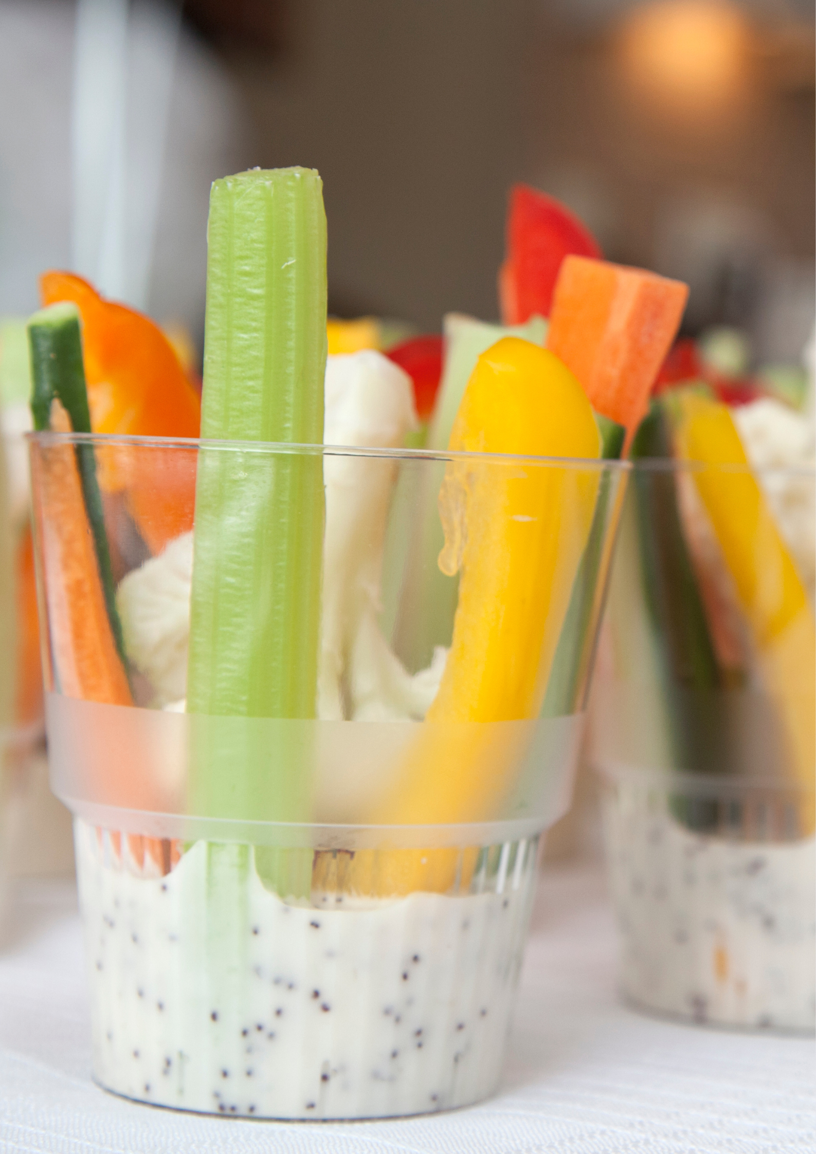 A cup filled with vegetables and dip on a table
