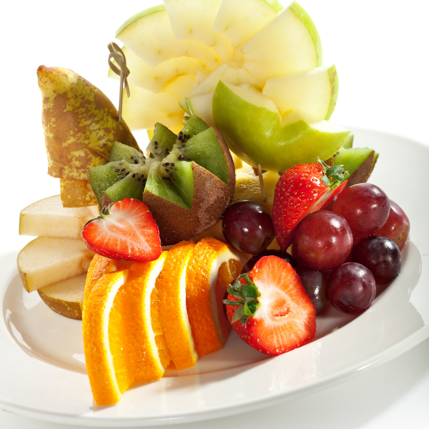A plate of food with rice and vegetables on a table next to a bottle of beer.