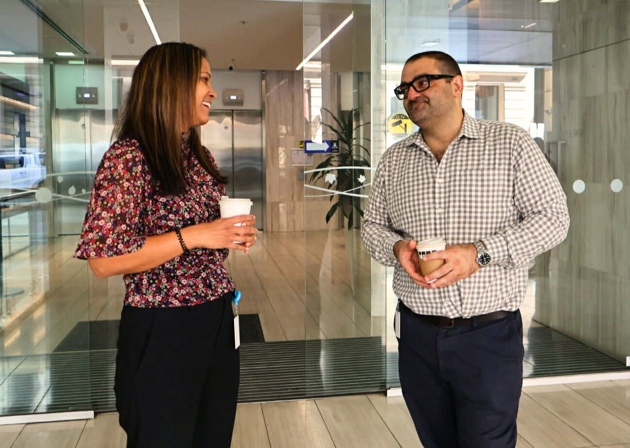A large office building with a lot of windows on a sunny day.