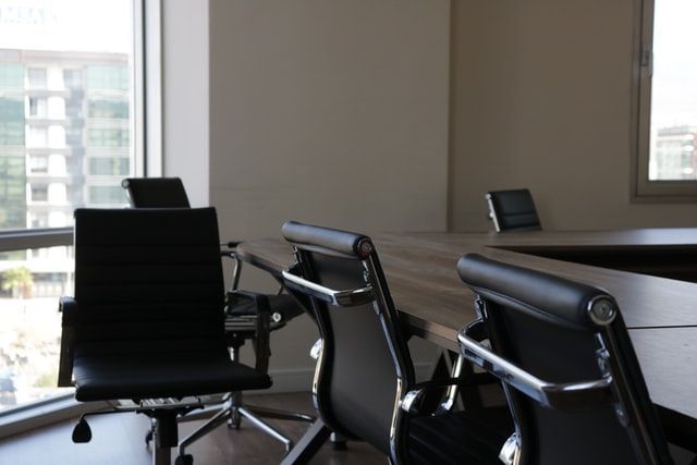 A conference room with a table and chairs and a window